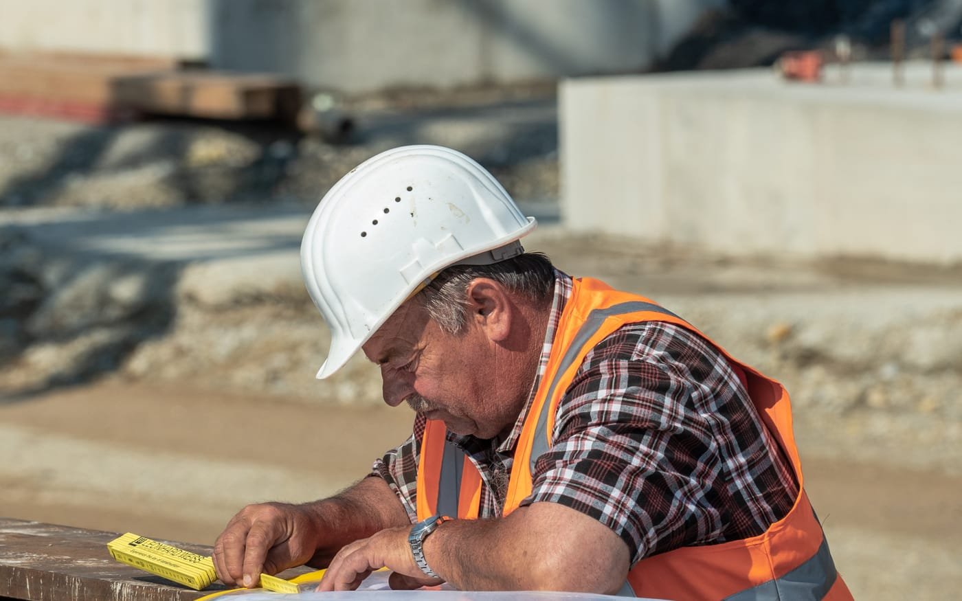 Conducteur de travaux consultant les plans d'exécution sur un chantier